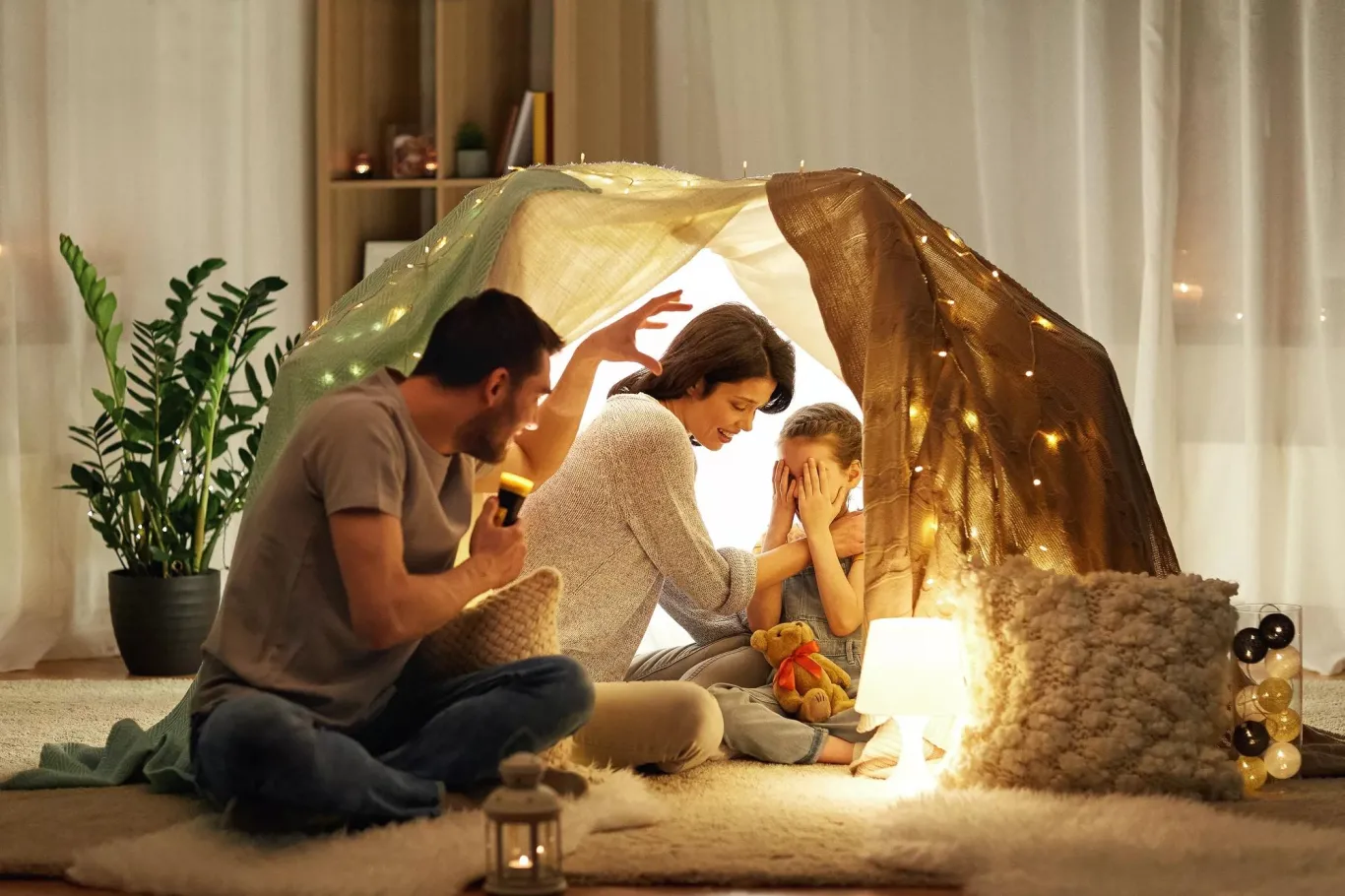 Una familia acampando en una tienda en su sala de estar.