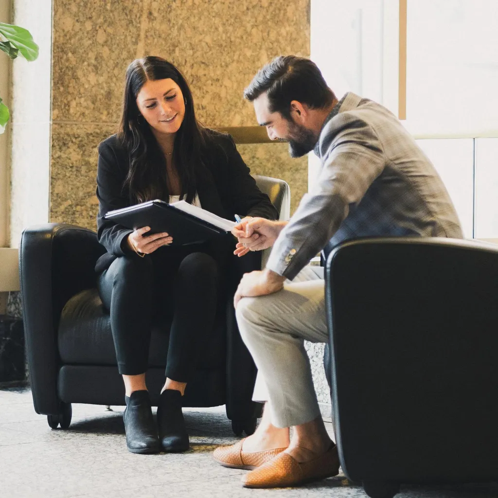 A man and woman meeting in a corporate lobby.