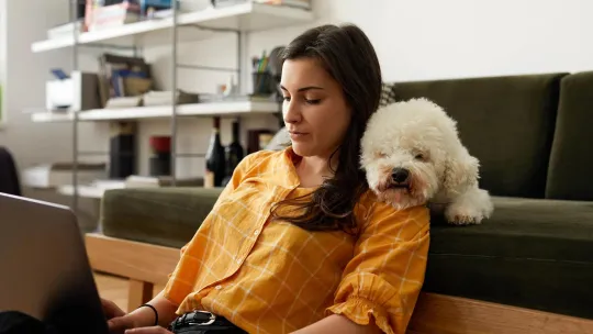 A woman sitting with her dog reviewing her retirement account